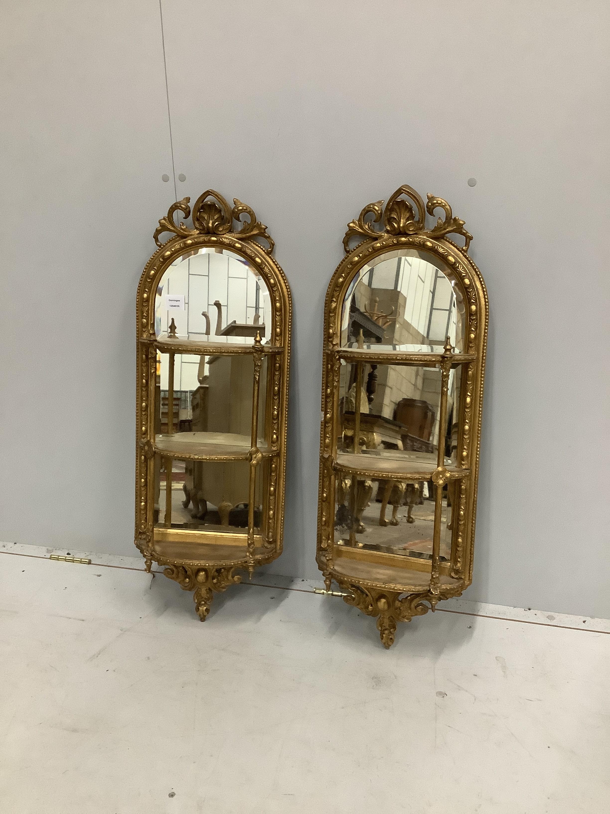 A pair of Victorian giltwood and composition mirrored three tier wall brackets, width 32cm, height 85cm